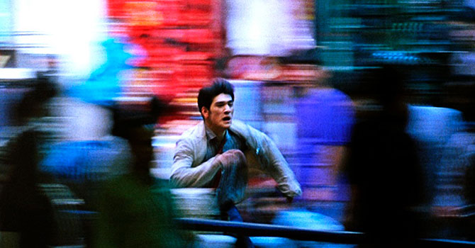 An image of a man running with a background full of motion blur, showing a slow shutter speed.