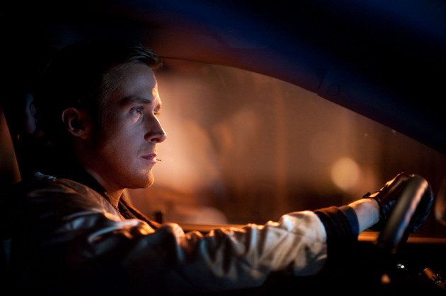 Shot from the film "Drive" showing a man driving a car with a blurred background.